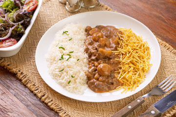Prato Executivo Estrogonofe de Carne Brasileiro com Arroz, Batata Palha e Salada em Mesa de Madeira