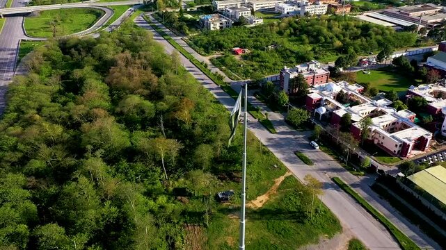 Pakistani flag waving with a background of houses