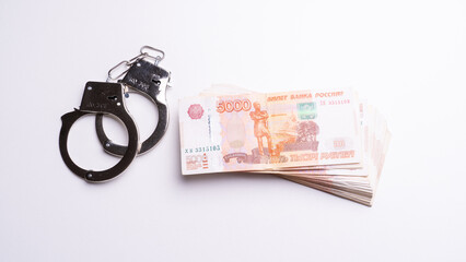 Police handcuffs and cash on white background top view concept crime corruption bribes.