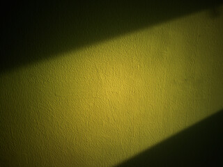 Dramatic ray of light on the grunge olive wall backdrop