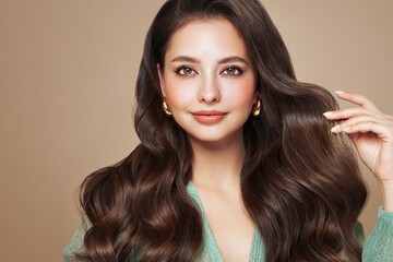 Naklejka premium Brunette girl with perfect makeup. Smiling beautiful model woman with long curly hairstyle. Care and beauty hair products