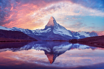Stellisee lake glows at sunset with perfect Matterhorn reflection in clear alpine water. Swiss Alps...