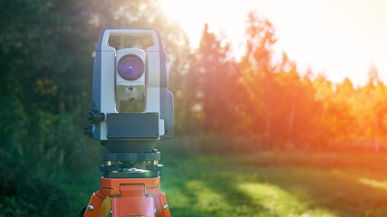 Surveying instrument is standing in a field. The instrument is a total station, which is used to...
