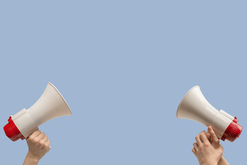 Megaphone in woman hands on a blue background.