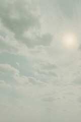 Soft-filtered image of a dramatic sky with textured clouds and sunlight creating a subtle halo...