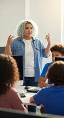 Non-binary teen teaching coding to diverse group in computer lab