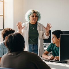 Non-binary teen teaching coding to diverse group in computer lab