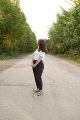 Young attractive woman standing on rural road