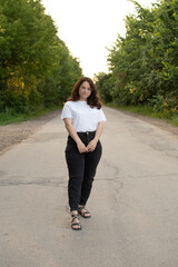 Young attractive woman standing on rural road