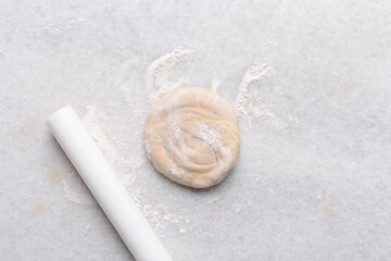 Overhead view of paratha dough rolled out, top view of flaky flatbread dough, process of making paratha