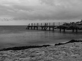 old wooden pier long exposure black and white