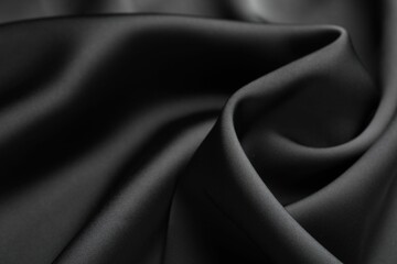 Obraz premium Crumpled black silk fabric as background, closeup