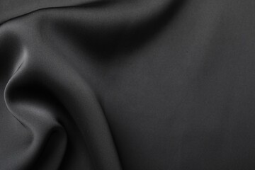 Crumpled black silk fabric as background, top view