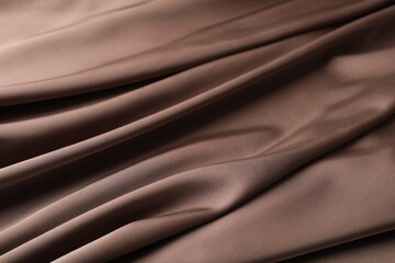 Crumpled light brown silk fabric as background, closeup