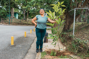 Hispanic Woman planting a tree for a better future and environment