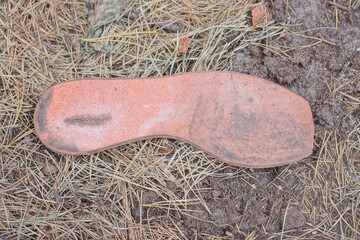 one old torn dirty pink shoe insole lies on the gray ground in the street