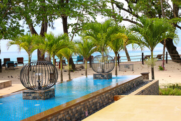 Luxury resort pool with palm trees and ocean view