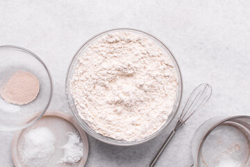 Mise en place of ingredients for making bread, All purpose flour vital wheat gluten and yeast on a marble countertop, process of making bread