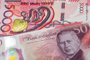5000 Kazakhstani tenge and 50 British pound banknotes. International trade concept