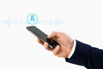 Young businessman using mobile phone on light background, closeup