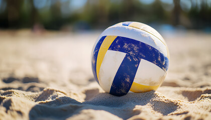 Volleyball ball sits on sandy beach. Ball in yellow, blue, white colors. Summer vacation, sports and recreation at seashore. Team sport, beach play, game competition during holiday