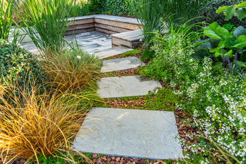 Detail of garden path with stones with bark mulch and native plants. Landscaping and gardening...