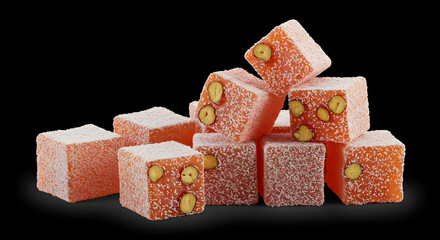 Colorful Turkish delight cubes stacked artistically, showcasing a variety of textures and flavors, with a focus on the nut-filled pieces against a dark background