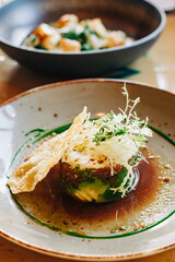 Culinary delight features colorful vegetables and crispy elements on an elegant plate in a gourmet restaurant setting