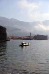 Boat near the Old Town, Budva, Montenegro. City with mountains in the background. Adriatic Sea