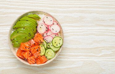 Poke bowl, a traditional hawaiian dish with diced raw salmon, avocado, vegetables served with rice and vegetables, a healthy meal on white wooden background, copy space