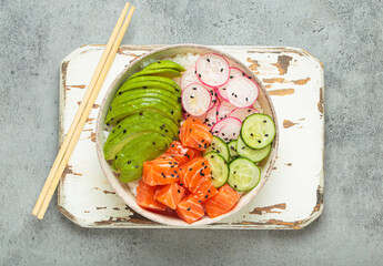 Poke bowl, a traditional hawaiian dish with diced raw salmon, avocado, vegetables served with rice and vegetables, a healthy meal