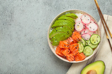Poke bowl, a traditional hawaiian dish with diced raw salmon, avocado, vegetables served with rice and vegetables, a healthy meal, copy space