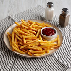 Homemade Golden French Fries with Ketchup, side view.
