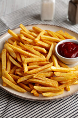 Homemade Golden French Fries with Ketchup, side view.