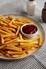 Homemade Golden French Fries with Ketchup, side view.