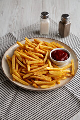 Homemade Golden French Fries with Ketchup, side view.