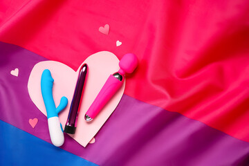 Vibrators with paper hearts on bisexual pride flag. Valentine's Day celebration