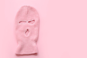 Knitted balaclava on pink background