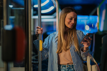 Young woman using smartphone on a bus at night