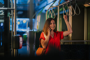 Young woman talking on smartphone while riding bus at night