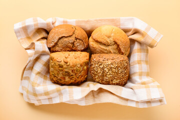 Box with different delicious buns on beige background