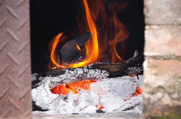 Lighting the fire for a barbecue with wood and charcoal. 