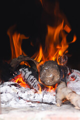 Lighting the fire for a barbecue with wood and charcoal. Vertical format. 