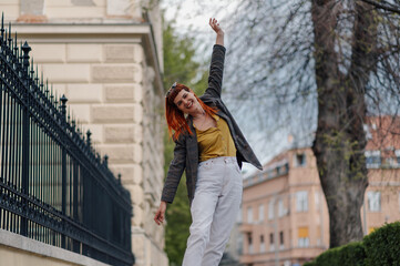 Carefree stylish woman dancing in the city street