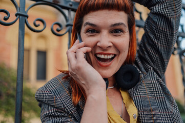 Enthusiastic businesswoman laughing while talking on phone