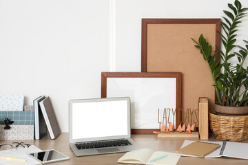 Stylish workplace with houseplant, notebooks and laptop