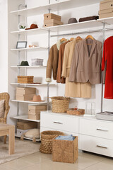 Big wardrobe with different stylish clothes and accessories in dressing room