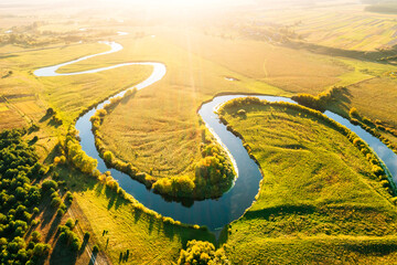 Serene meandering river carves through the landscape during golden hour. Location place Polissya...