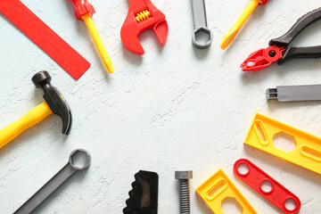 Set of toy tools on light grunge background. Labor Day celebration