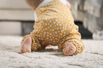 Cute little baby crawling on floor at home, closeup